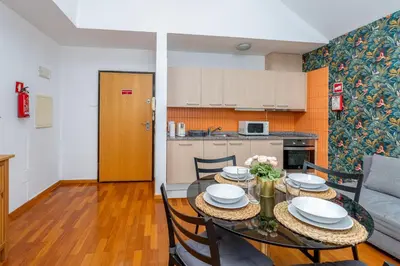 a dining room and kitchen with a table and chairs at Cedofeita Exclusive with parking included in Porto