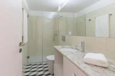 a bathroom with a sink and a toilet and a mirror at Host Wise - Colorful Stunning Sunlit Flat in Porto