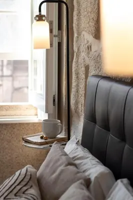a lamp sitting next to a couch with a cup on a table at LovelyStay - Aurora Mezzanine in Porto
