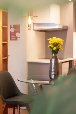 a glass table with yellow flowers in a vase at LovelyStay - Aurora Mezzanine in Porto