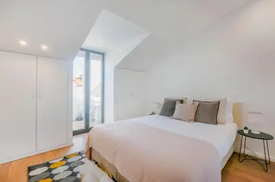 a white bedroom with a large bed and a window at Porto City Elegant Retreat in Porto