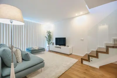 a white bedroom with a large white bed with pillows at Porto City Elegant Retreat in Porto