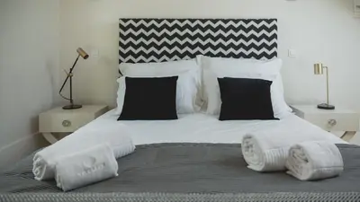 a bed with black and white pillows on it at viterbo'8 - The Artists House in Porto
