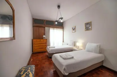 a bedroom with two beds and a dresser in it at FLH Porto Spacious Apartment with Balcony in Porto