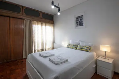 a bedroom with a white bed with two towels on it at FLH Porto Spacious Apartment with Balcony in Porto