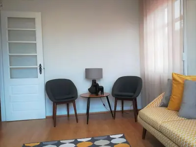a living room with two chairs and a table with a lamp at North Star Flats @ Dom Luís I Bridge in Vila Nova de Gaia