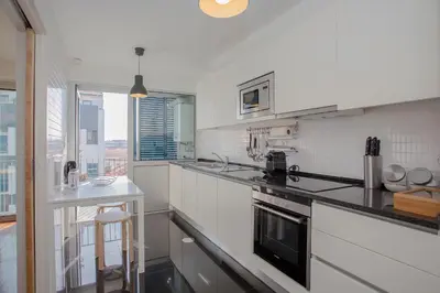 a kitchen with white appliances and a counter top at Liiiving in Porto | Bright Light Apartment in Porto