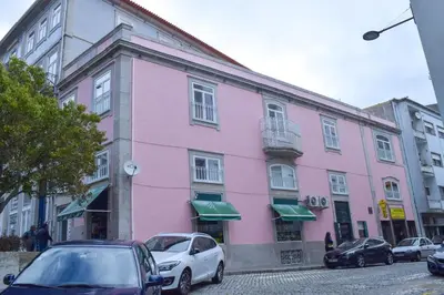 a pink building with cars parked in front of it at Tito Studio Terrace in Porto