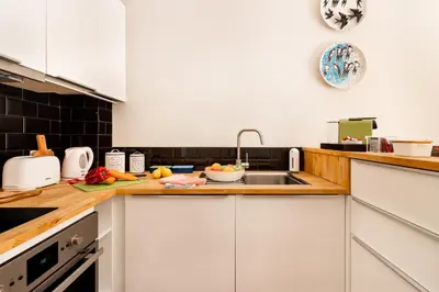 a kitchen with white cabinets and a sink at Exquisite Retreat in a Traditional Area of Porto in Porto