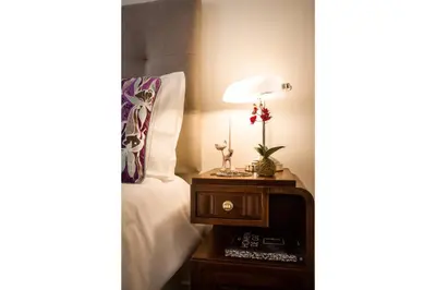 a bed with a table with a lamp on it at Exquisite Retreat in a Traditional Area of Porto in Porto