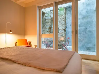 a bedroom with a bed and a large window at Domum 3 in Porto