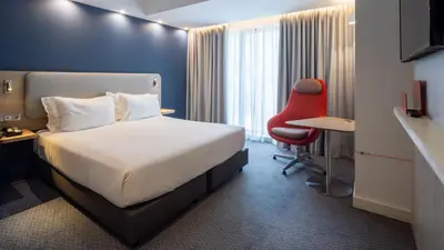a restaurant with a bar and tables and chairs at Holiday Inn Express Porto City Centre by IHG in Porto