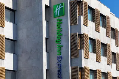 a glass door of a store with two blue chairs at Holiday Inn Express Porto City Centre by IHG in Porto