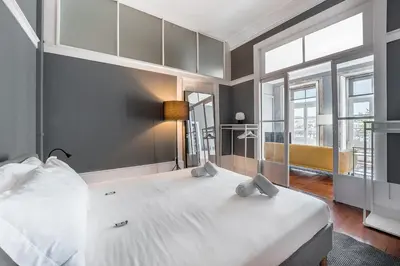 a bedroom with a large white bed with a large window at GuestReady - Innvict Residences in Porto