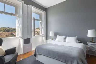 a white bedroom with a bed and a window at GuestReady - Innvict Residences in Porto