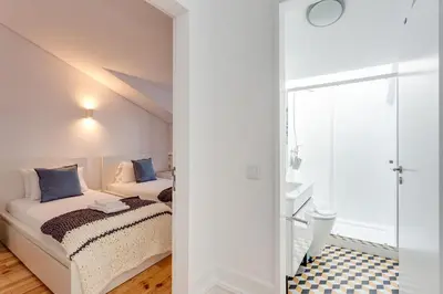 a bedroom with a bed and a glass door at Almada Luxurious Duplex by DA'HOME in Porto