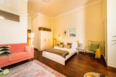 a bedroom with a bed and a couch at DA'HOME - Cedofeita Art Studio in Porto