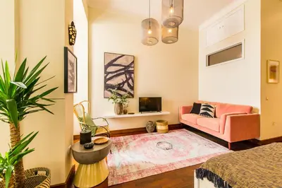 a living room with a pink couch and a tv at DA'HOME - Cedofeita Art Studio in Porto