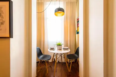 a table and chairs in a room with a window at DA'HOME - Cedofeita Art Studio in Porto