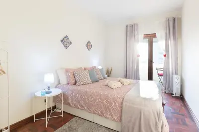 a white bedroom with a bed and a table at Cozy Apartment Alegria Balcony in Porto