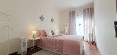 a white bedroom with a bed and a window at Cozy Apartment Alegria Balcony in Porto