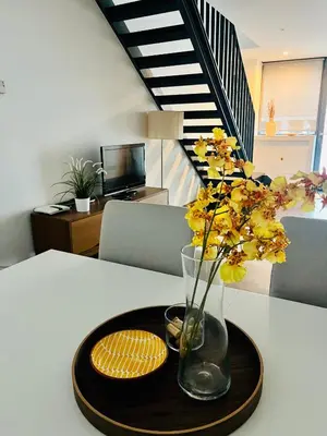 a table with a vase with yellow flowers and plates on it at PATEO LUSO - Cozy Apartment City Center in Porto