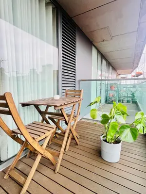 a wooden table and chairs on a balcony with a plant at PATEO LUSO - Cozy Apartment City Center in Porto