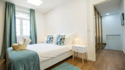 a bedroom with a white bed and a window at Oporto Yellow Villas in Porto