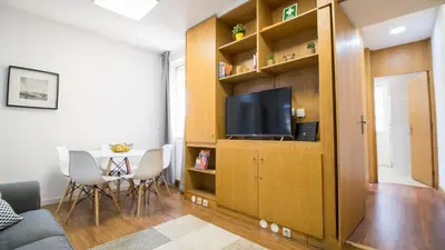 a living room with a television and a table with chairs at Oporto Yellow Villas in Porto