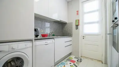a white kitchen with a washing machine in it at Oporto Yellow Villas in Porto