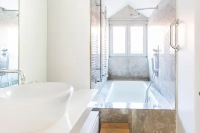 a white bathroom with a tub and a sink at APOSENTUS - Downtown Porto Modern Penthouse in Porto