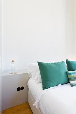 a white couch with green and white pillows on it at BOUTIQUE Rentals - Toledos One & Only Apt in Historical center of Porto in Porto