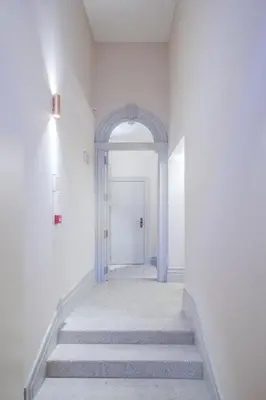 a hallway with stairs leading to a white door at BOUTIQUE Rentals - Toledos One & Only Apt in Historical center of Porto in Porto