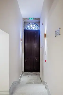 a hallway with a dark wooden door with a window at BOUTIQUE Rentals - Toledos One & Only Apt in Historical center of Porto in Porto