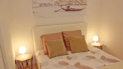 a small bedroom with a bed with two lamps at São João Oporto Residence I & II in Porto