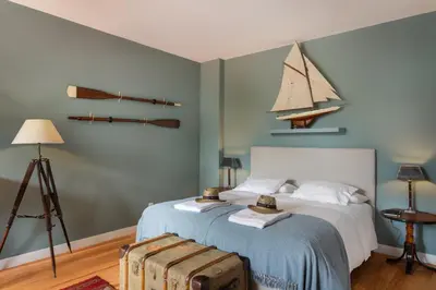 a bedroom with a bed with a boat on the wall at VIVA Casa da Praça with Pool and terrace in Porto