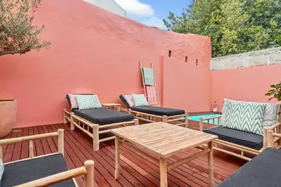a group of chairs and a table on a deck at VIVA Casa da Praça with Pool and terrace in Porto