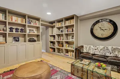a living room with a couch and a clock on the wall at VIVA Casa da Praça with Pool and terrace in Porto