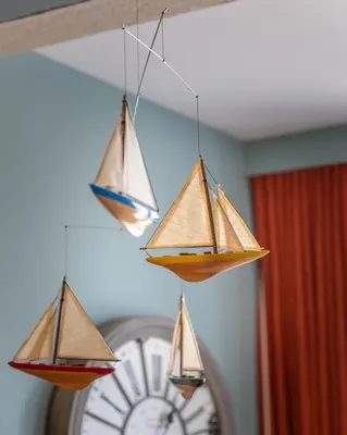 three paper boats hanging from a ceiling with a clock at VIVA Casa da Praça with Pool and terrace in Porto