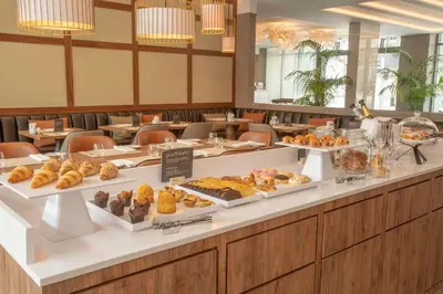 a buffet line with different types of pastries on display at NH Porto Jardim in Porto