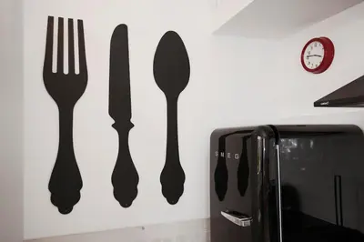 a wall with fork and knife on a wall next to a microwave at GET Lights and Books in Flat in Porto