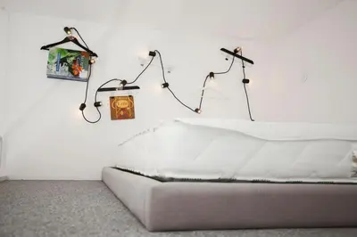 a white room with a couch and lights on the wall at GET Lights and Books in Flat in Porto