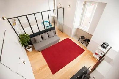 a living room with a couch and a red rug at GET Lights and Books in Flat in Porto