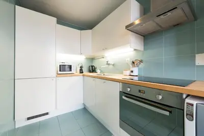 a kitchen with white cabinets and a stove at Fontainhas Design Apartment by DA'HOME in Porto