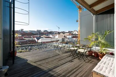 a balcony with a table and chairs on a building at Fontainhas Design Apartment by DA'HOME in Porto