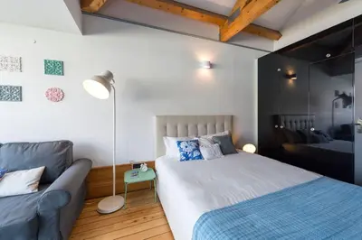a bedroom with a bed and a couch at Fontaínhas Stylish Apartment by DA'HOME in Porto