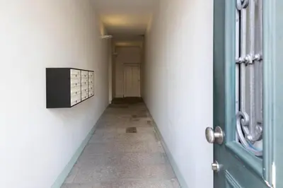 a hallway with a blue door and a tile floor at Fontaínhas Stylish Apartment by DA'HOME in Porto
