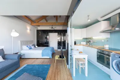 a kitchen and living room with a bed in a room at Fontaínhas Stylish Apartment by DA'HOME in Porto