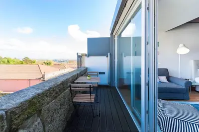 a balcony with two chairs and a couch on a building at Fontaínhas Stylish Apartment by DA'HOME in Porto