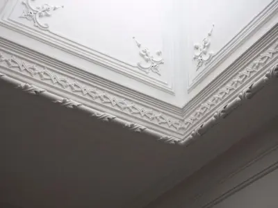 a white coffered ceiling with ornate molding at O da Joana in Porto